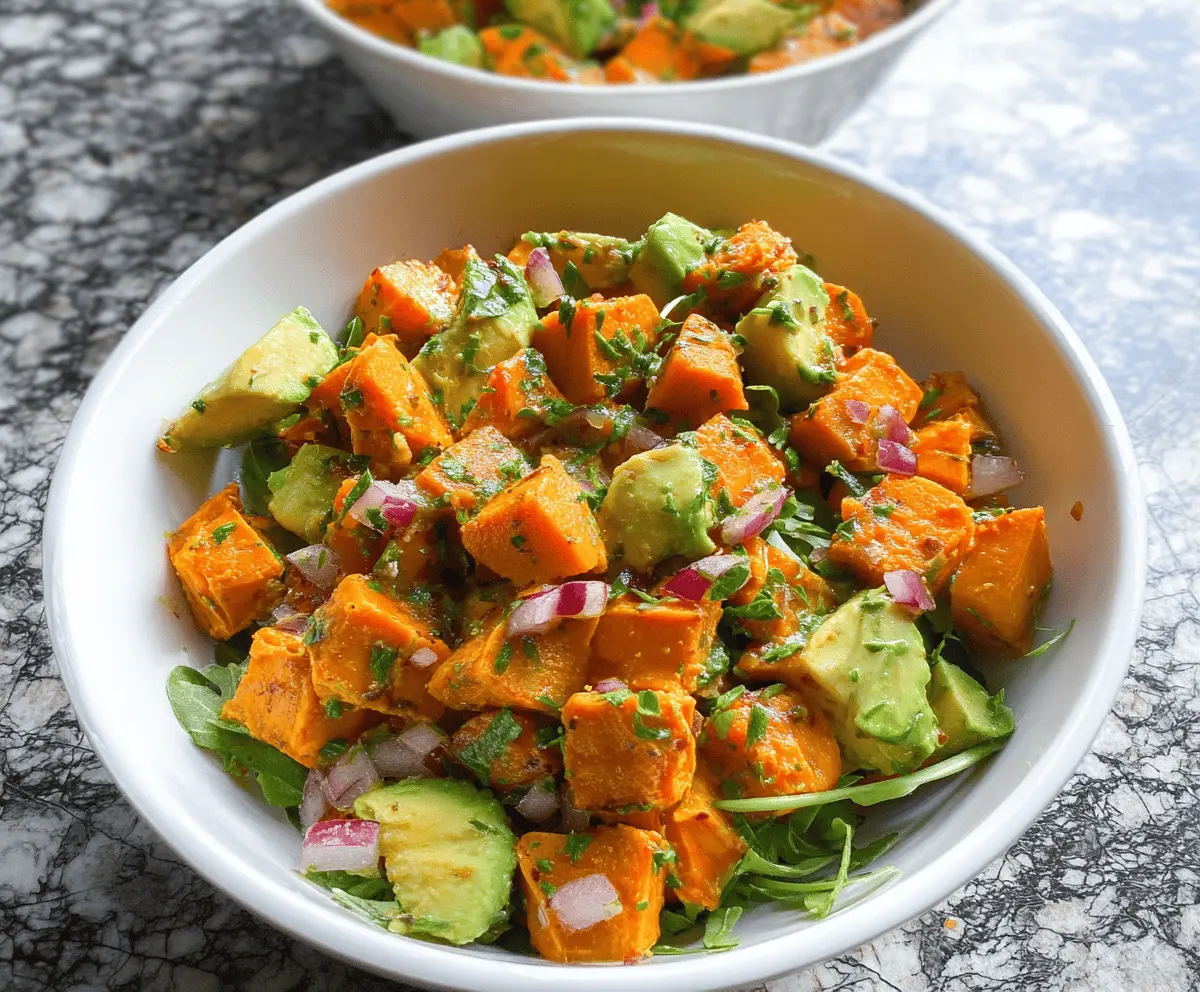 Colorful sweet potato salad with creamy avocado, fresh herbs, and vibrant vegetables in a bowl—perfect for a healthy, delicious meal.