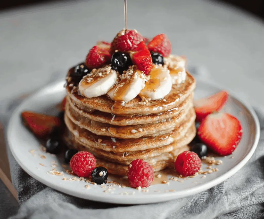 Fluffy cottage cheese protein pancakes topped with fresh berries on a breakfast plate.