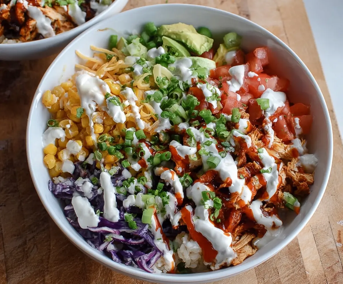 Delicious BBQ Chicken Ranch Bowl topped with fresh vegetables and herbs.