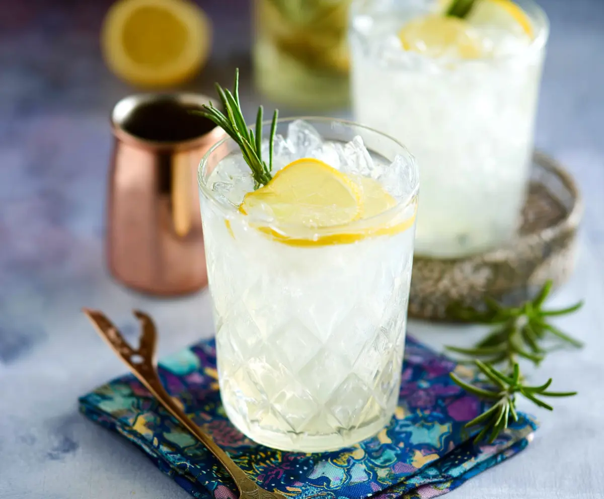 Refreshing Rosemary Gin Fizz cocktail garnished with fresh rosemary and lemon slices.