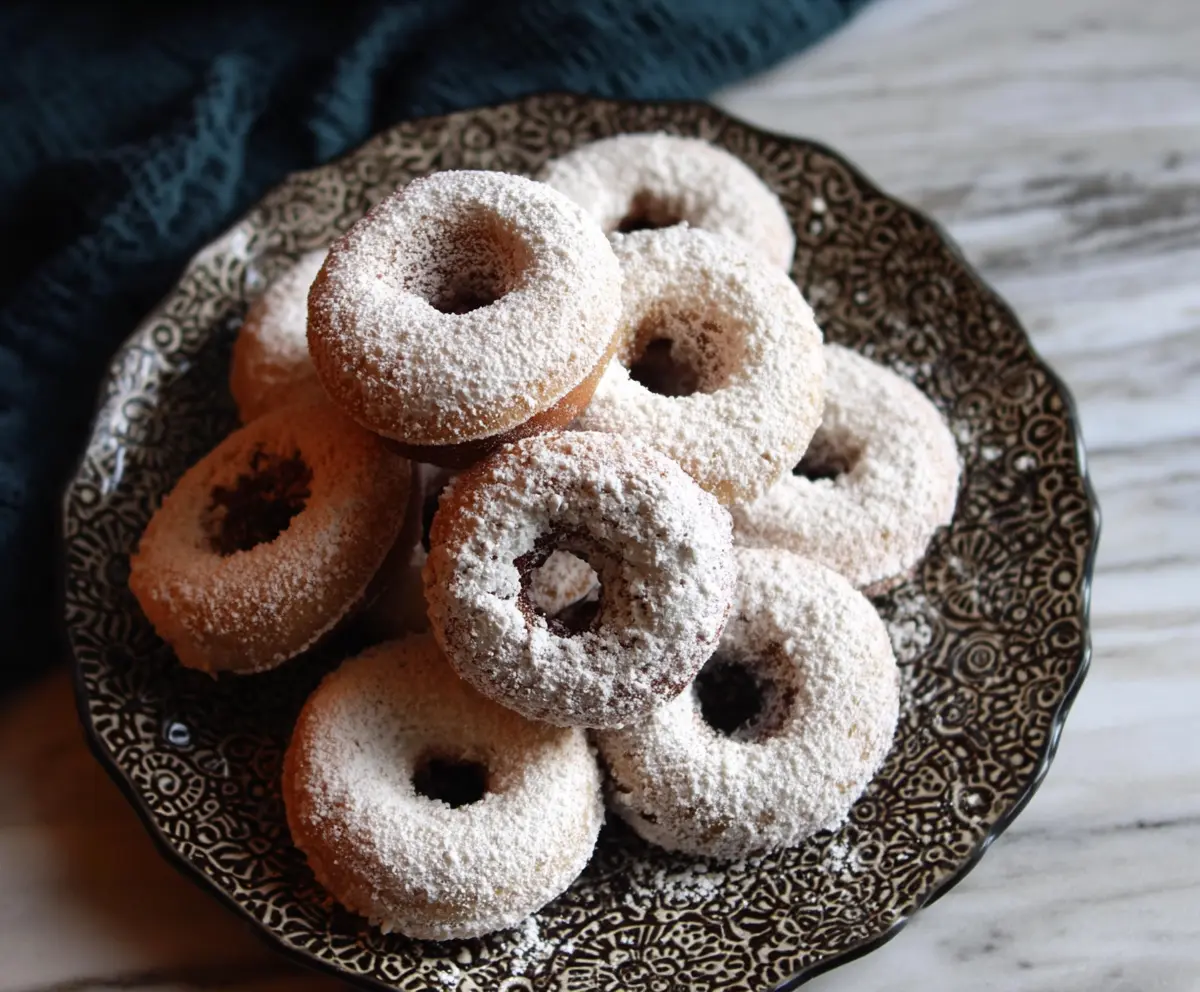 Delicious baked sourdough discard powdered sugar donuts on a plate