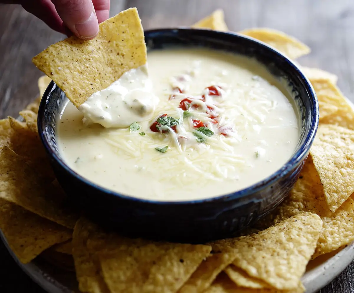 Creamy Crock Pot Queso Blanco Dip with melted cheese and spices in a slow cooker.