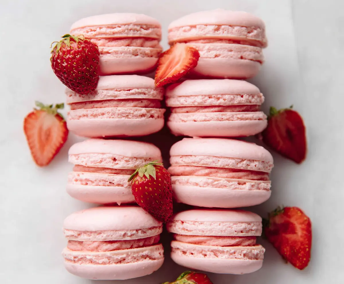 Beautiful French strawberry macarons with a smooth pink filling, perfect for dessert lovers.