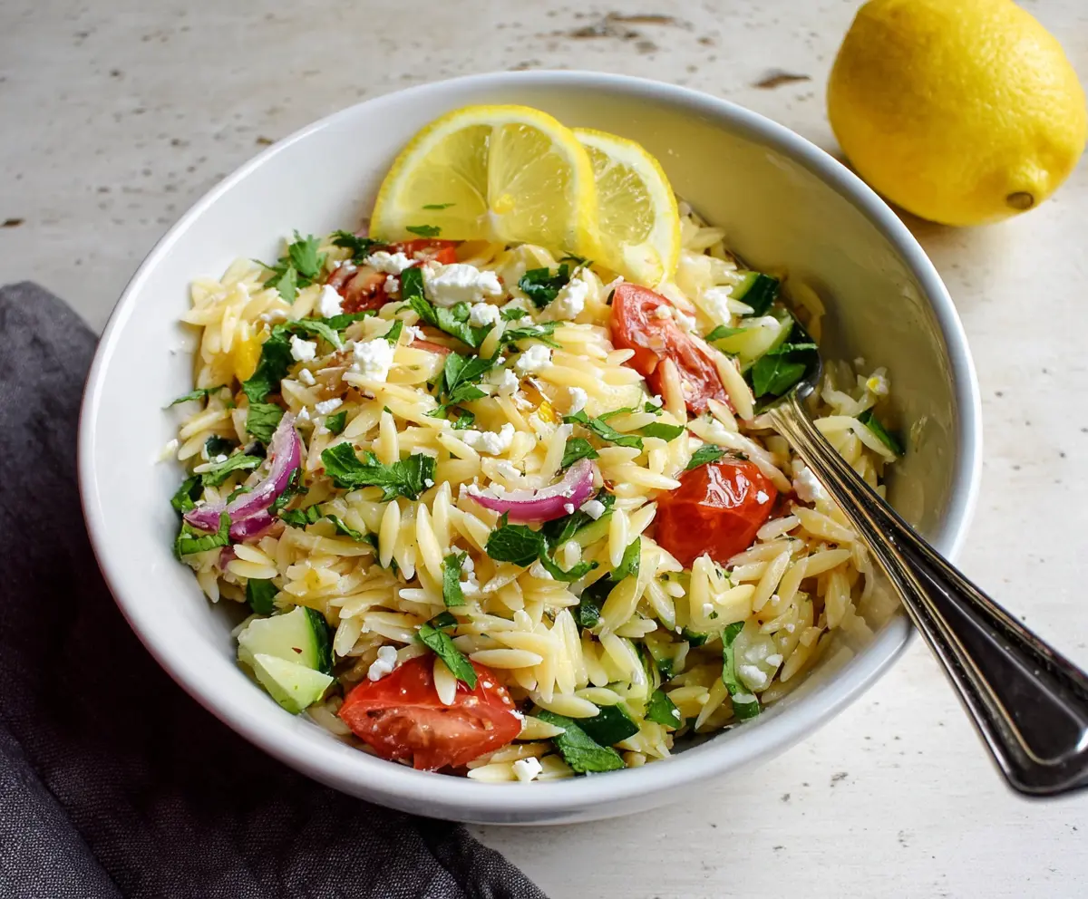 Fresh Lemon Orzo Pasta Salad with herbs and vegetables in a bowl, perfect for summer lunches