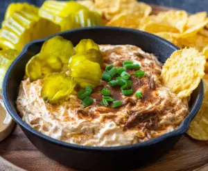 Delicious Mississippi Pot Roast Dip served in a bowl with fresh herbs and crispy bread on the side.