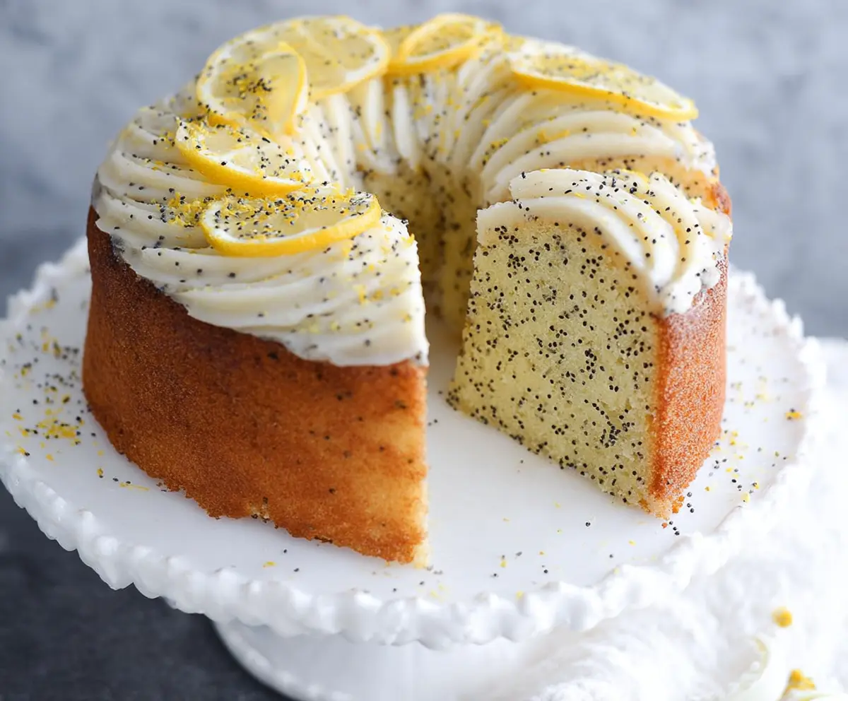 Delicious Lemon Poppy Seed Cake on a plate with fresh lemon slices and poppy seeds.
